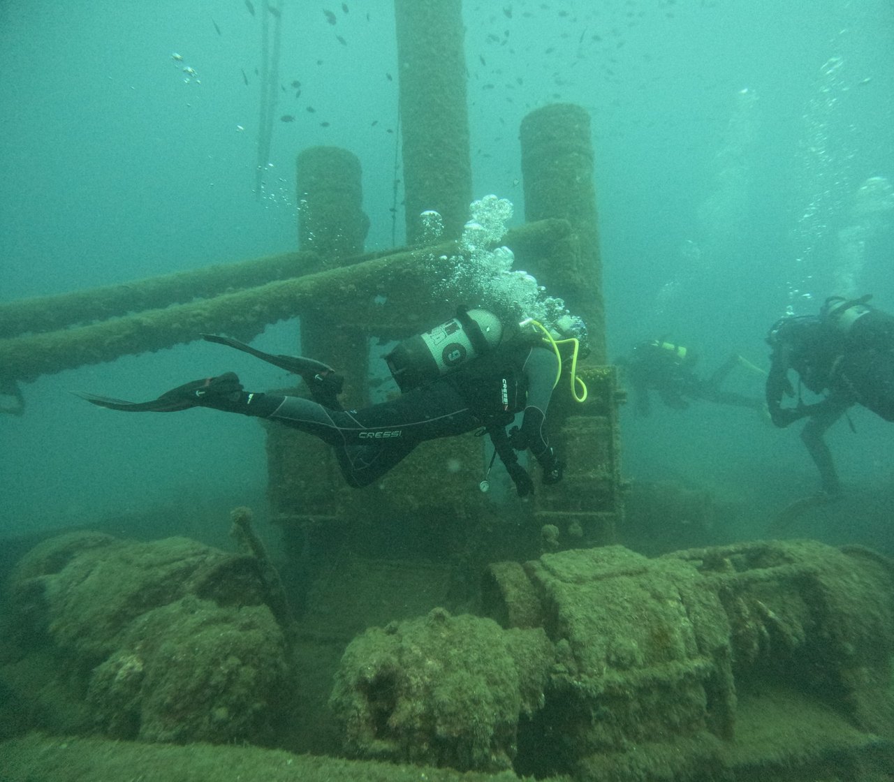 Divers exploring a sunken wreck structure