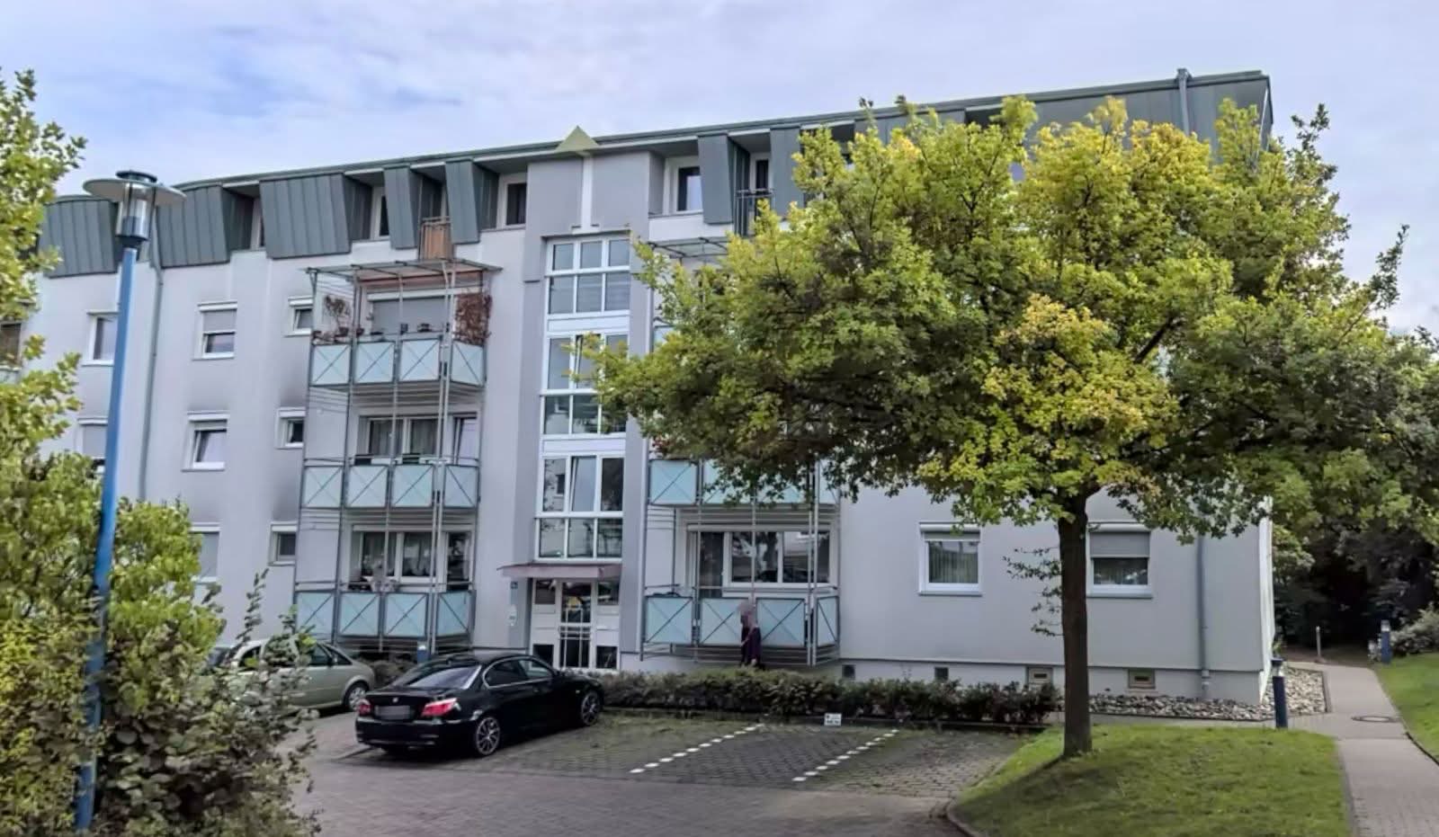 Wohnanlage Bolanden, Ansicht mit Treppenhausturm und Baumbestand