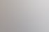 Ein Mann in Anzug und Hemd lächelt, lehnt an einer Wand mit unscharfem Bild.