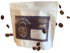 A white bag of Legendforge Coffee Triptych Blend with coffee beans scattered around it.