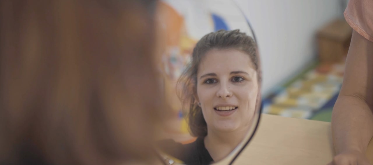 Frau betrachtet ihr Spiegelbild in einem Handspiegel