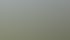 Grüne Wiese vor einer Stadtsilhouette mit modernen Gebäuden und Bäumen unter bewölktem Himmel.
