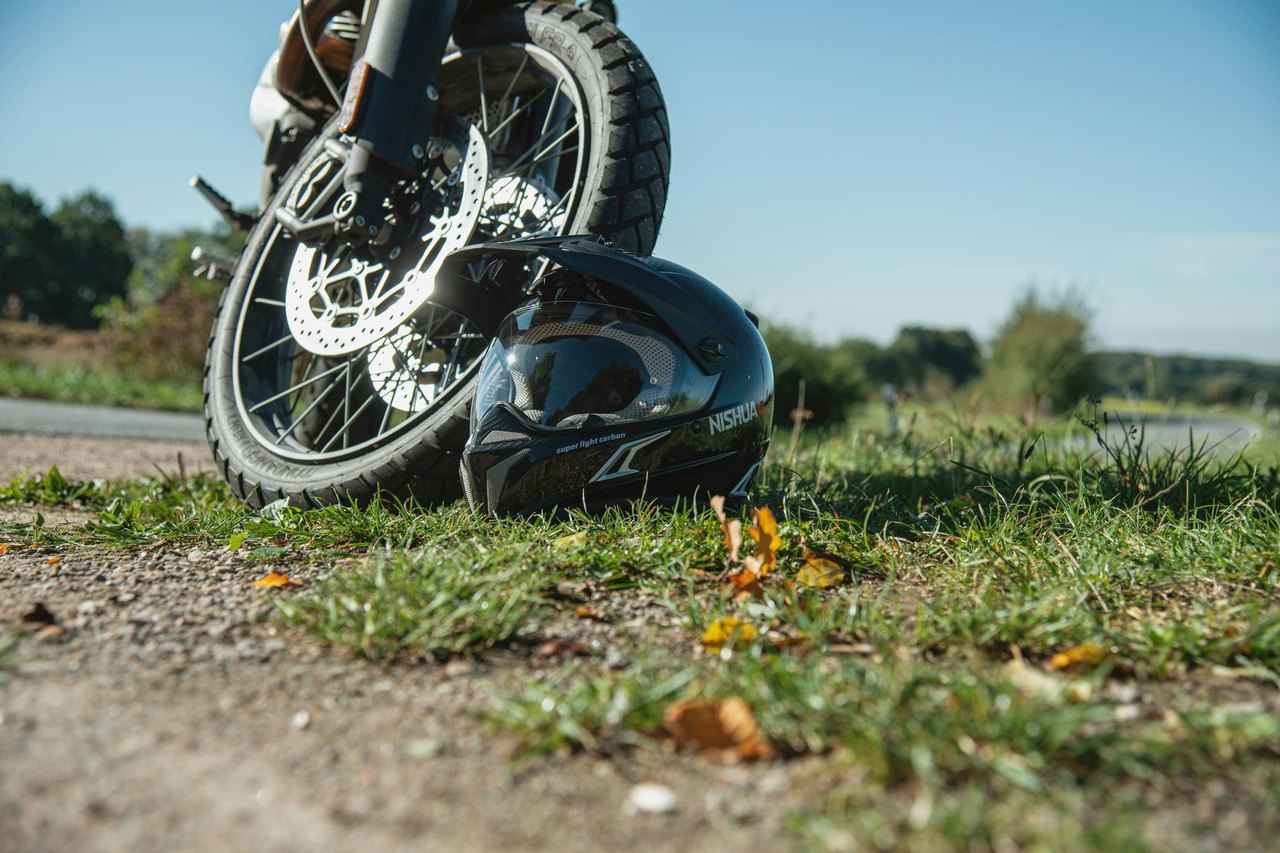 Umgestürztes Motorrad mit Helm am Straßenrand