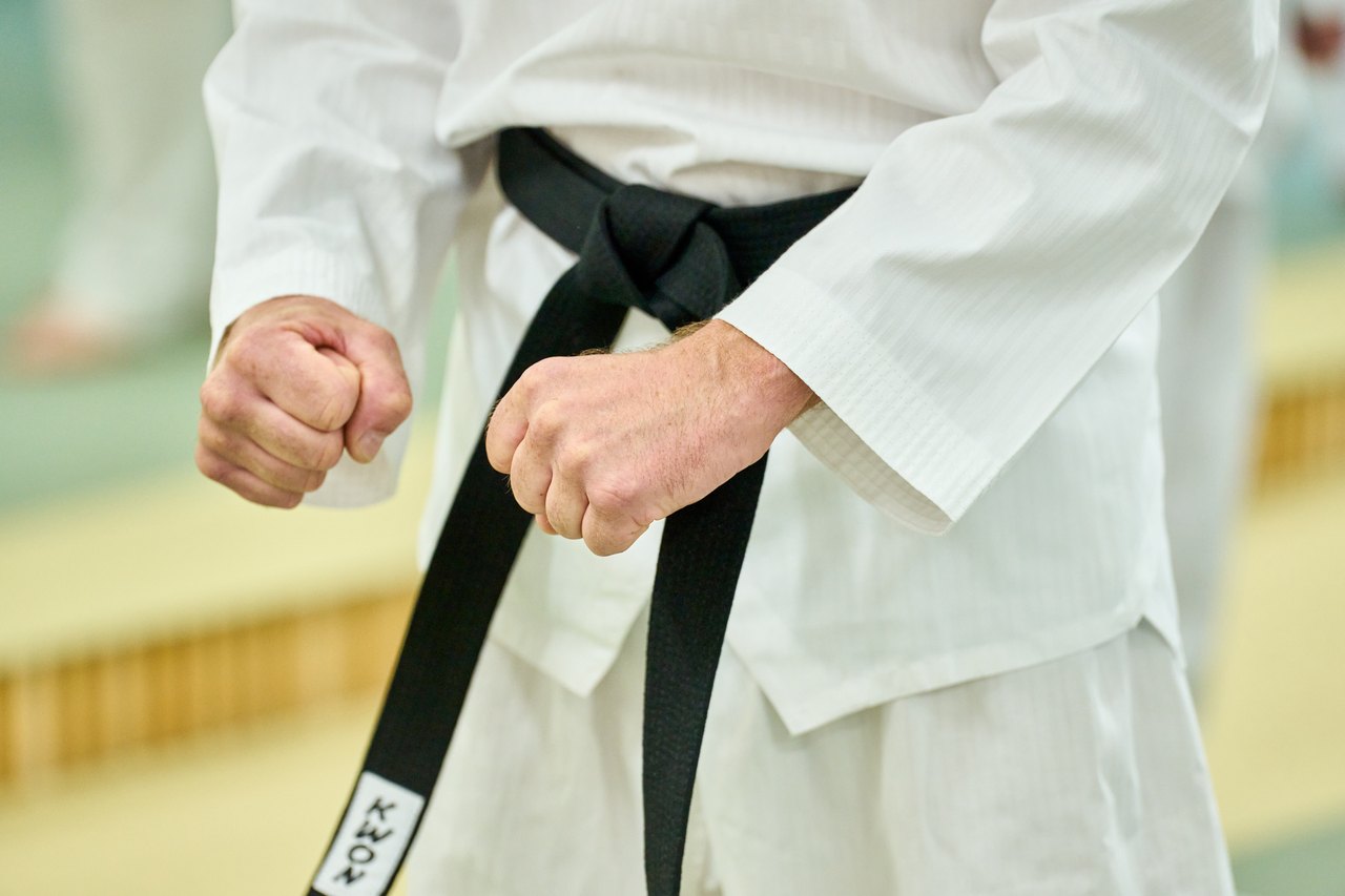 Nahaufnahme: Fäuste und schwarzer Gürtel im weißen Dobok bei SOMA Taekwondo Bonn