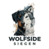 Gesichtshälfte eines Dobermanns kombiniert mit einer Wolfshälfte über dem Schriftzug Wolfside Siegen auf schwarzem Grund.