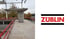 Baustelle mit ZÜBLIN-Logo, Betonstütze und rotem Sicherheitsgeländer.