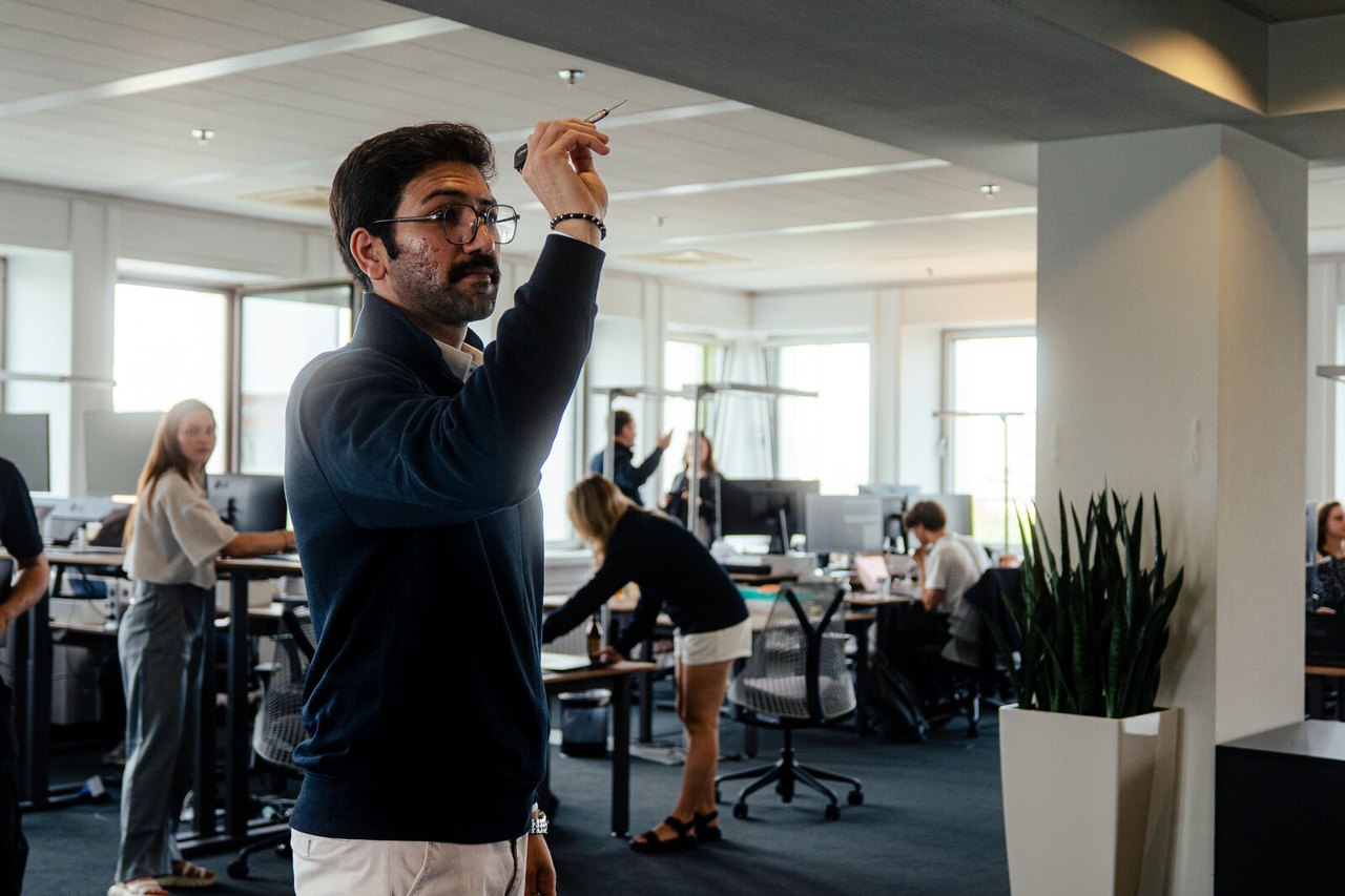 Kollege im Office, im Hintergrund das Team bei der Arbeit