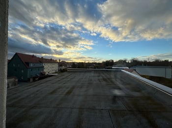 Blick von einer Dachfläche über die Nachbardaecher bei Abendhimmel