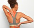 Woman in sports bra clutching lower back, red pain indicator visible.