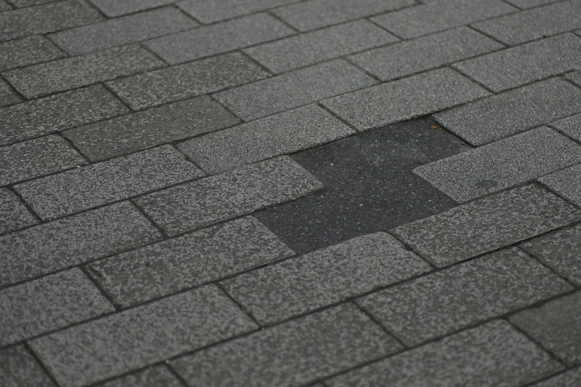 Weathered asphalt shingle roof with missing shingles, showing how long a roof lasts in Texas heat near Sherman