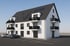 Modernes Mehrfamilienhaus mit weißen Fassaden, schwarzen Dächern, Balkonen und Solarmodulen, zwei Autos parken davor.
