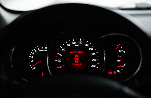 A car dashboard with a warning light lit among the gauges, the moment a check engine light in Corona, California forces a decision