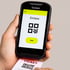 Hand scannt ein Ticket mit QR-Code und dem Text "EINLASS" auf einem mobilen Ticketing-Gerät.