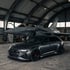 Dunkelgrauer Audi RS 6 Avant und ein Kampfflugzeug in einem Hangar.