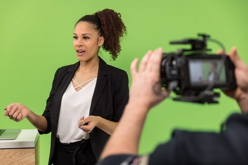 Referentin vor Greenscreen wird von einer Kamera aufgenommen