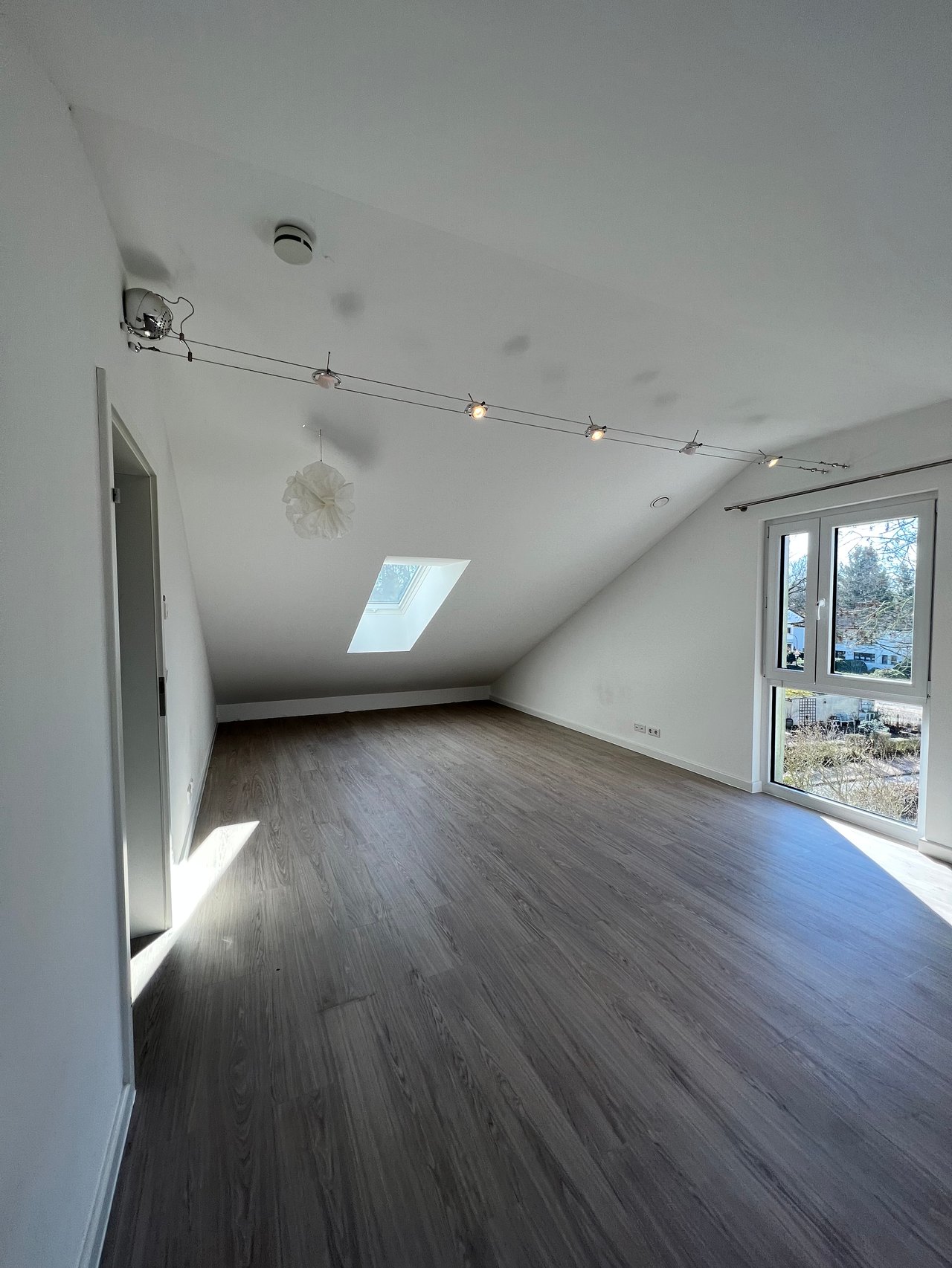 Dasselbe Dachzimmer nach der Sanierung mit neuem Boden und weißen Wänden