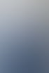 Ein lächelnder Mann im blauen Anzug mit verschränkten Armen und buntem Einstecktuch vor einem hellen Hintergrund.
