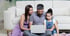 Familie mit Kind sitzt gemeinsam vor einem Laptop und beschäftigt sich mit ihrer finanziellen Planung.