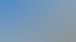 Zwei moderne weiße Mehrfamilienhäuser mit Balkonen unter blauem Himmel mit weißen Wolken.