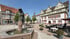 Historischer Marktplatz mit Brunnen, Fachwerkhäusern, Außengastronomie und dem Rathaus unter blauem Himmel.