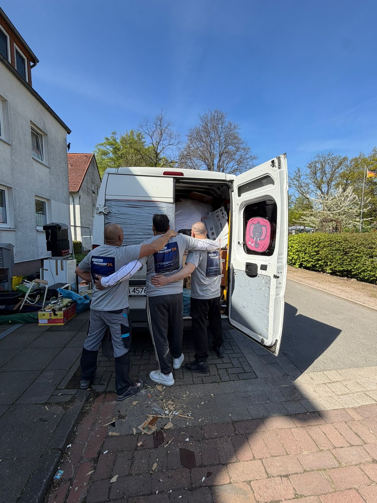 Team von Entrümpelung Hannover24 bei einem Einsatz, Arm in Arm, ohne erkennbare Gesichter