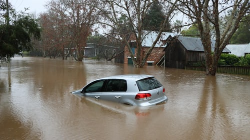 Car driving through standing water on a flooded road, as happens on Port Charlotte streets in the wet season