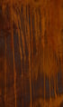 Rostige Metalloberfläche mit vertikalen, orangefarbenen Oxidationsspuren und dunkler, verwitterter Textur.
