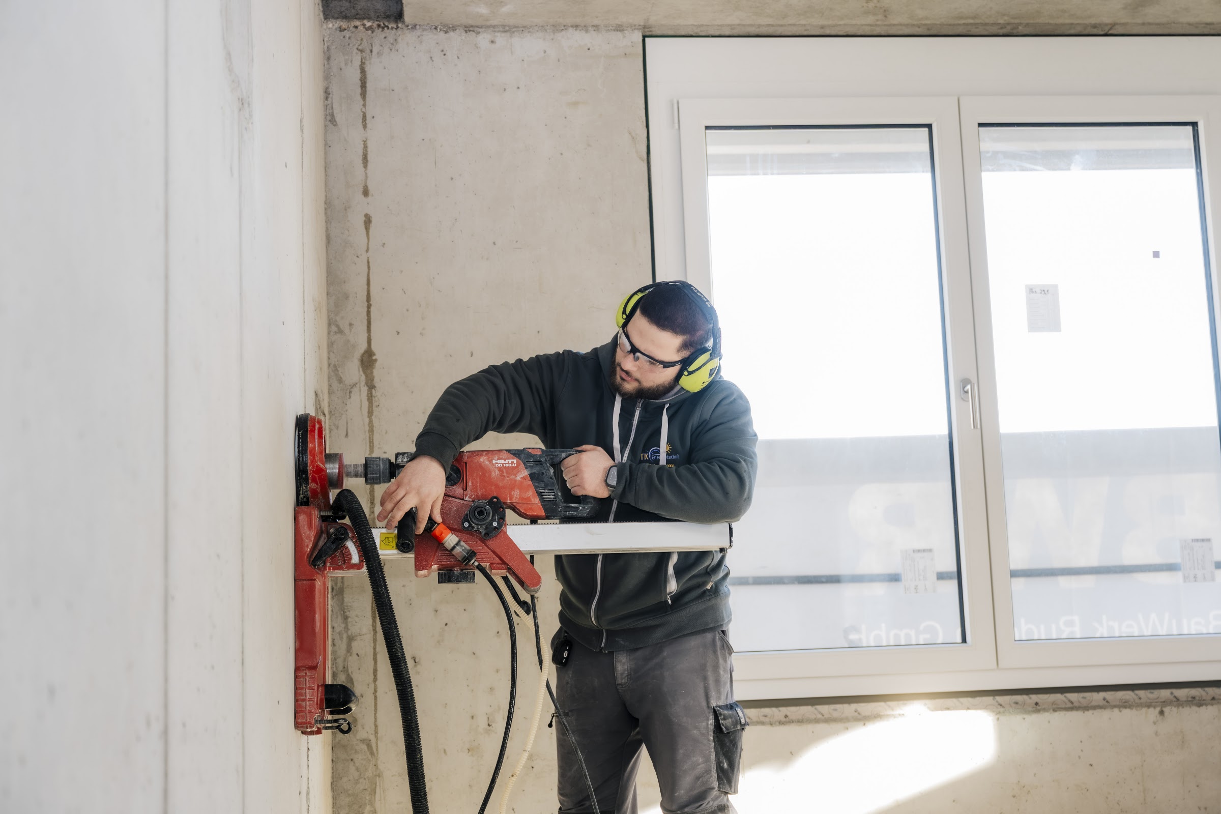 Elektroniker setzt eine Kernbohrung im Neubau