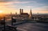 Hantelbank und Langhantel auf einem Dach mit Münchener Skyline bei Sonnenuntergang.