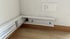 Weiße Kabelkanäle entlang der Wand mit verlegten Kabeln, daneben eine weiße Steckdose.