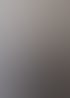 Ein lächelnder, kahlköpfiger Mann mit Brille und schwarzem Poloshirt steht vor einer grauen Betonwand.