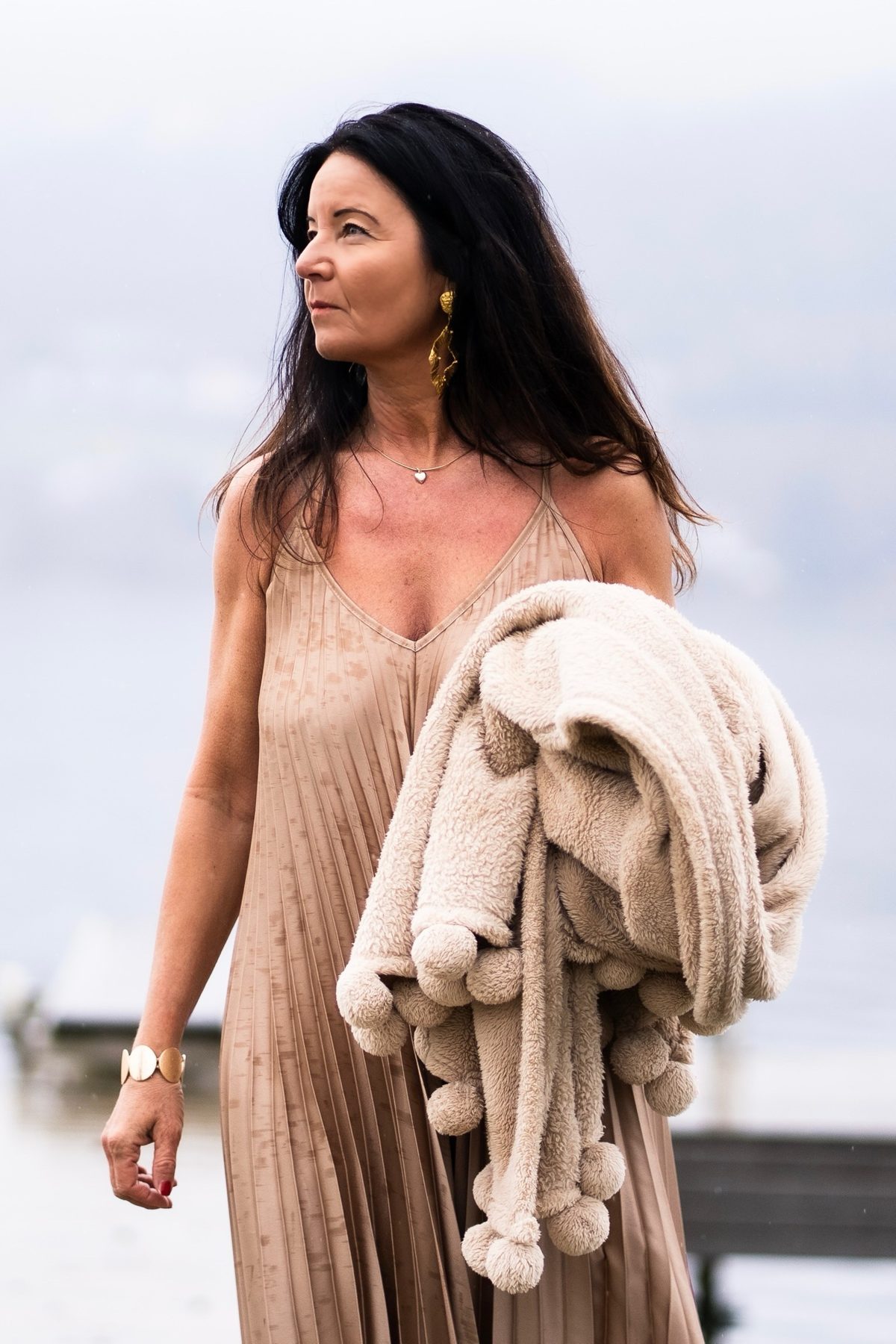 Manuela Reudink am See, mit einer Decke über dem Arm, den Blick nach vorn