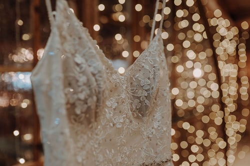 Hochzeitskleid mit Spitze vor warmem Lichter-Bokeh