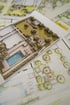 Detaillierte Gartenplanungsskizzen mit Pool, Rasenflächen, Bäumen und architektonischen Grundrissen in der Draufsicht.