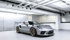 Ein grauer Porsche Targa 4S steht in einer modernen Garage mit freiliegenden Rohren und glänzenden Böden.