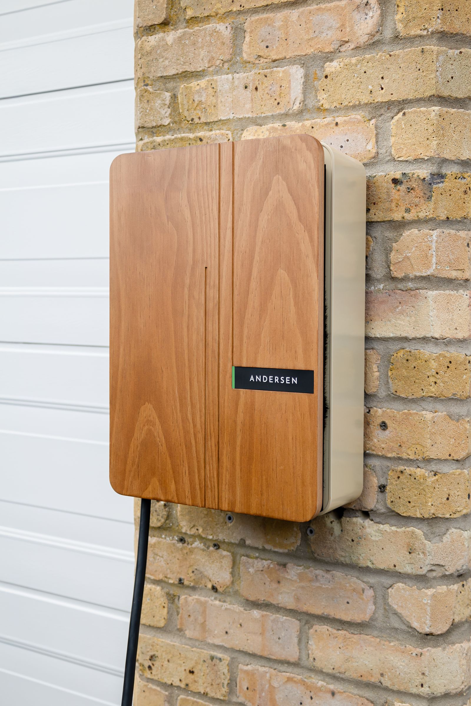 Level 2 EV charger mounted on a residential garage wall with the cable coiled