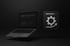 Laptop mit dunklem Bildschirm und einem Icon daneben, das ein Zahnrad mit einem Pfeil nach oben zeigt.