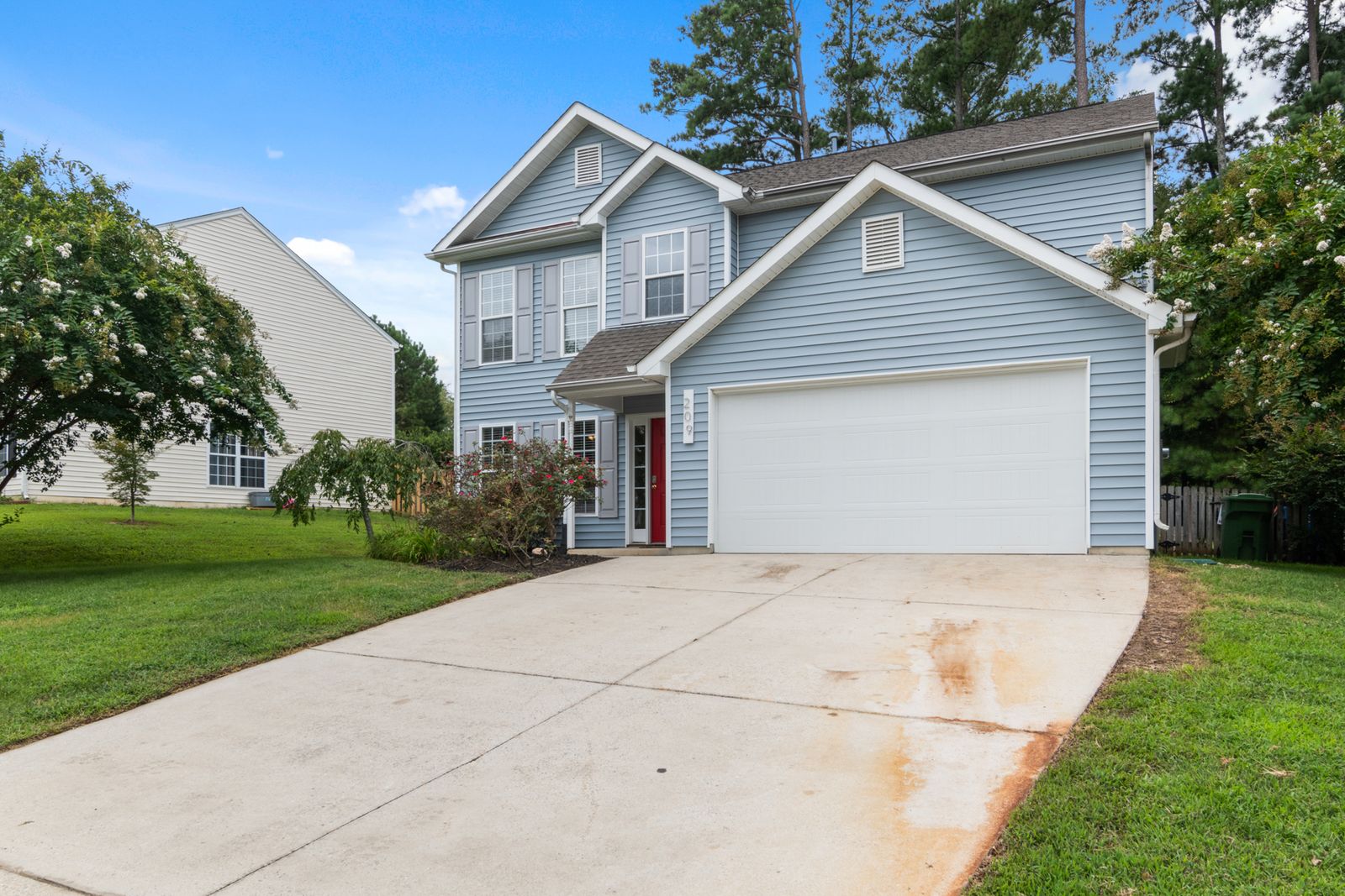 Two-story family home with a shingle roof and attached garage