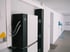 Schwarze und weiße AlphaESS-Batteriespeicher mit Kabeln an einer weißen Wand in einem modernen Raum.