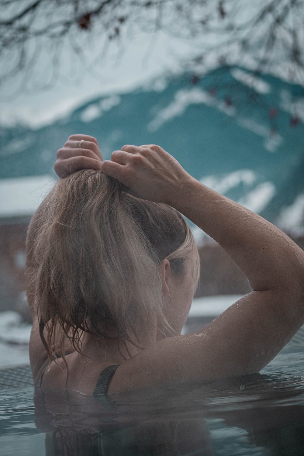 Frau im dampfenden Pool vor Bergen