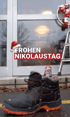 Schwarzer Stiefel mit orangefarbener Sohle, Schokoladen-Nikolaus und Weihnachtsmütze vor einer Tür. Text: "FROHEN NIKOLAUSTAG".