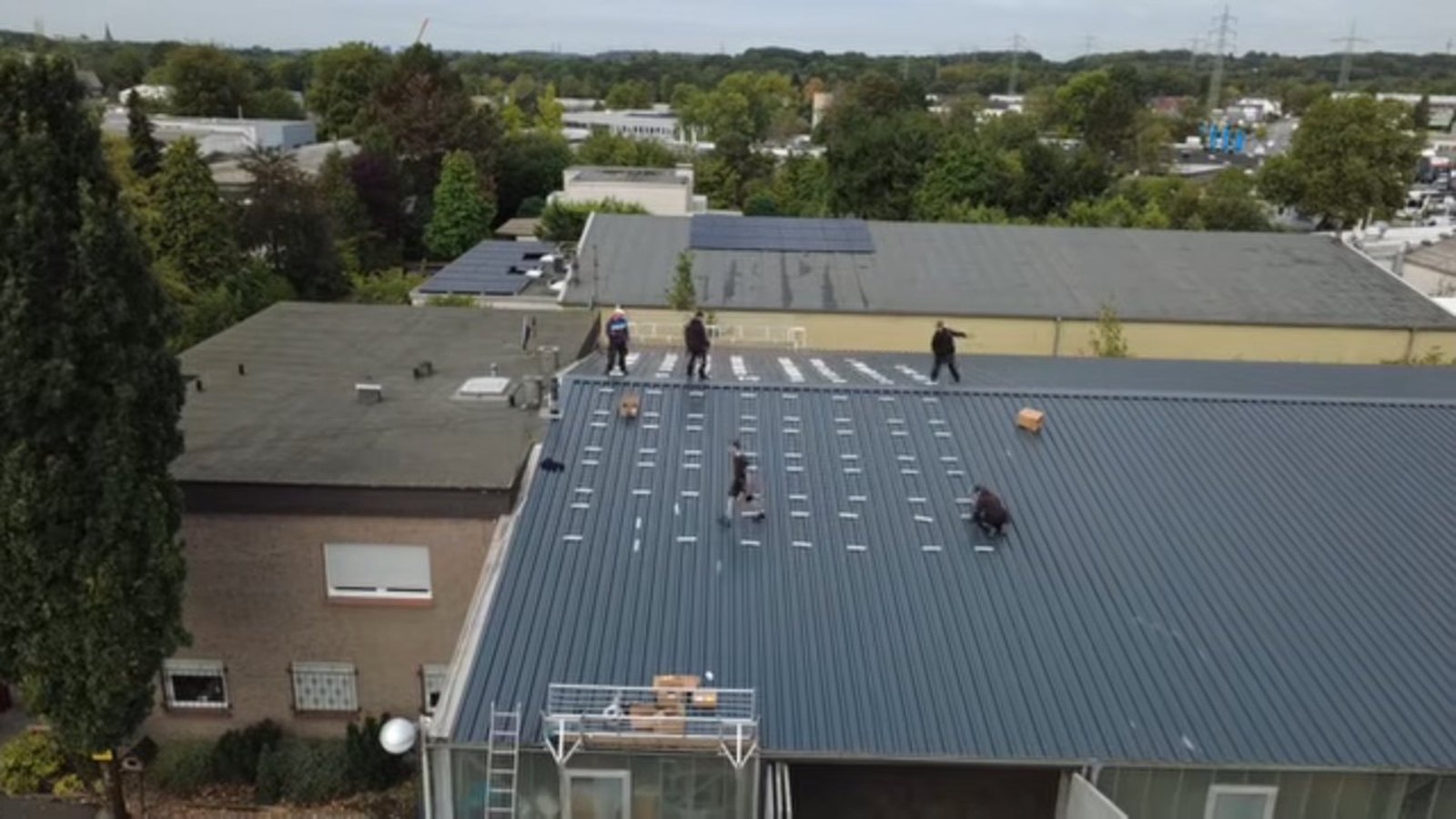 Montageteam auf dem Trapezblechdach der Gewerbehalle in Witten-Annen