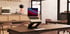 All-metal laptop stand on a coffee shop table with laptop, showing ergonomic setup