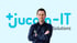 Mann mit verschränkten Armen vor blauem Jucom-IT Logo.