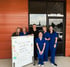 A healthcare team poses with a whiteboard.