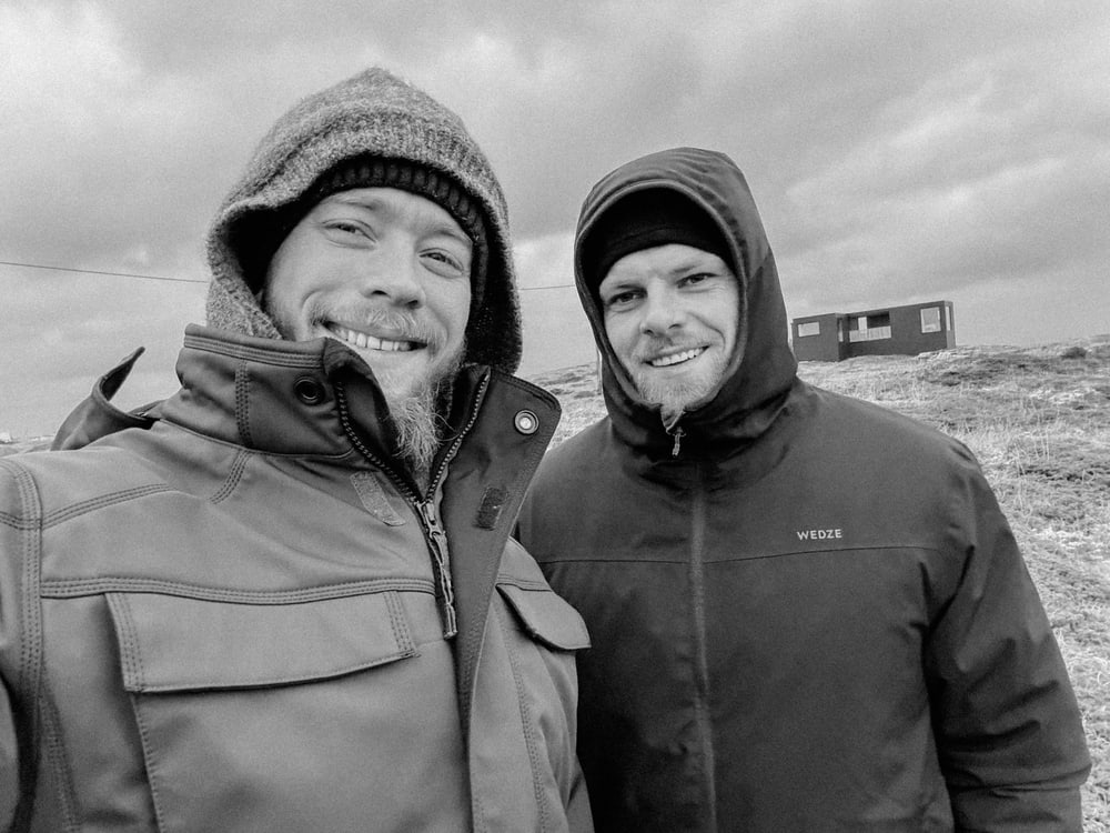 Selfie zweier Männer in Winterjacken, Schwarz-Weiß