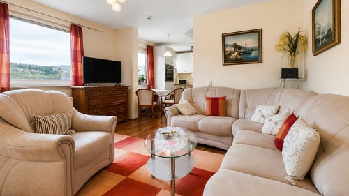 Wohnzimmer der Ferienwohnung in Bad Soden-Salmünster mit Sofaecke, Schreibtisch und Blick über den Spessart