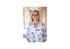 Stephanie Meller steht lächelnd mit Brille und einer weiß-blauen Blumenbluse vor einem hellen, unscharfen Hintergrund.