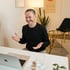 Lächelnder Mann mit Bart spricht in einem Videoanruf vor einem Laptop und gestikuliert mit den Händen.