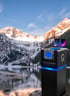 Schwarzer Kiosk mit blau leuchtendem Bildschirm, auf dem "GLOBAL COOLING" steht, vor dunklem Hintergrund.